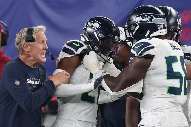 Seattle's Devon Witherspoon, center, celebrates a 97-yard interception return touchdown wi