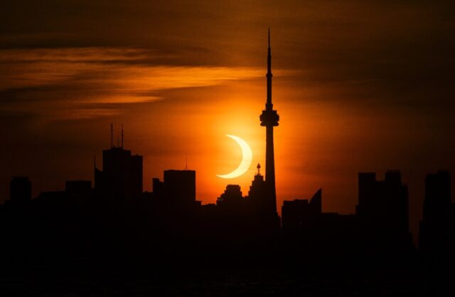 The sun rises behind the skyline during an annular eclipse in June 2021 in Toronto, Canada