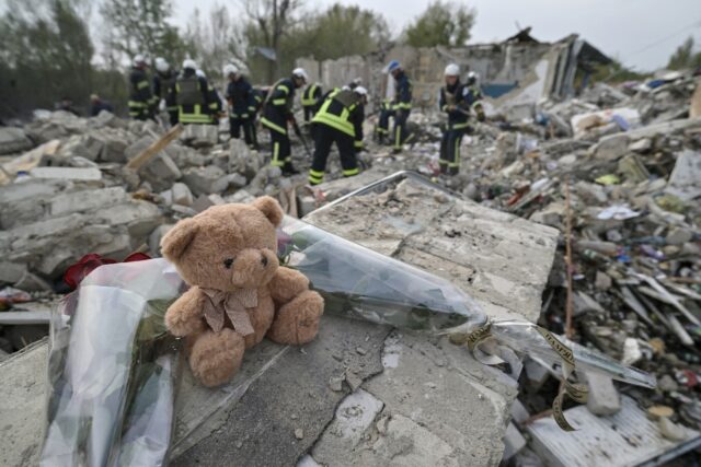 A teddy bear and flowers are displayed on the fragment of a wall in the village of Groze w