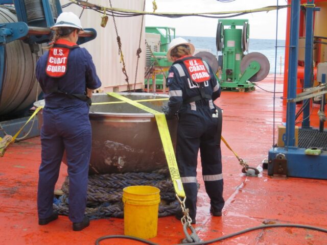 US Coast Guard engineers survey the recovered titanium endcap of the Titan sumbersible on