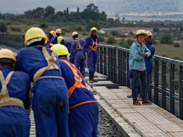 In this Wednesday, Nov. 23, 2016 file photo, Kenyan laborers and a Chinese foreman, right,