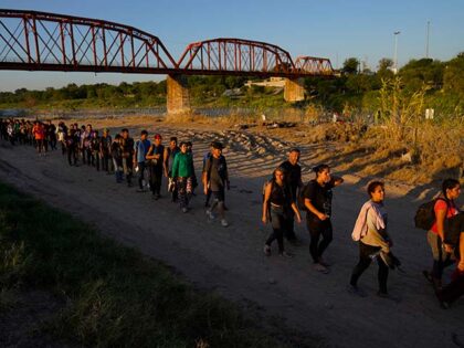 Migrants who crossed the Rio Grande and entered the U.S. from Mexico are lined up for processing by U.S. Customs and Border Protection, Sept. 23, 2023, in Eagle Pass, Texas. U.S. authorities say illegal border crossings from Mexico fell 14% in October from a month earlier, following three months of …