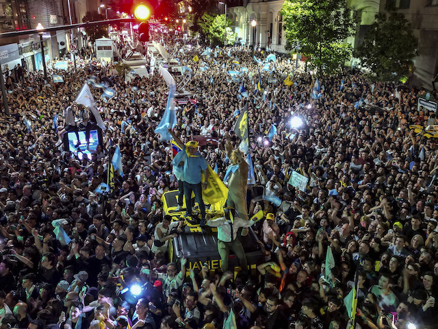 Supporters of presidential candidate Javier Milei celebrate outside his campaign headquarter his victory over Economy Minister Sergio Massa, candidate of the ruling Peronist party, in the presidential runoff election in Buenos Aires, Argentina, Sunday, Nov. 19, 2023. (AP Photo/Matias Delacroix)