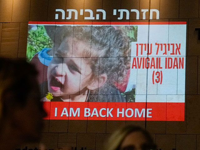 People walk past an image of 4-year-old Abigail Edan, a hostage held by Hamas who was rele