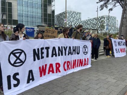 Activists hold up a banner denouncing Israeli Prime Minister Benjamin Netanyahu for Israel