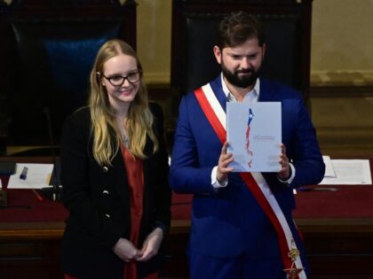 Chile's President Gabriel Boric (R) receives the text of the proposed new Constitution from the president of the Constitutional Council, Beatriz Hevia, during the closing ceremony of the Constitutional Process at the Hall of Honor of the National Congress in Santiago on November 7, 2023. Boric signed the decree that …