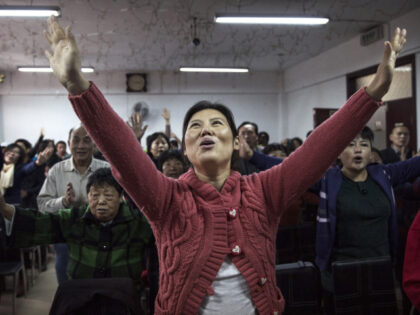 BEIJING, CHINA - OCTOBER 12:(CHINA OUT): A Chinese Christian woman sings during a prayer service at an underground independent Protestant Church on October 12, 2014 in Beijing, China. China, an officially atheist country, places a number of restrictions on Christians and allows legal practice of the faith only at state-approved …