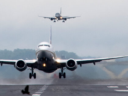 A flight takes off as another lands at Ronald Reagan Washington National Airport in Arling