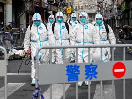 TOPSHOT - Health workers in protective gear walk out from a blocked off area after spraying disinfectant in Shanghai's Huangpu district on January 27, 2021, after residents were evacuated following the detection of a few cases of COVID-19 coronavirus in the neighbourhood. (Photo by STR / AFP) / China OUT …