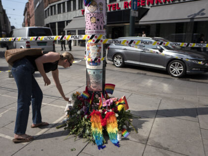 A woman lays down flowers at a makeshift memorial at the crime scene on June 25, 2022, in the aftermath of a shooting outside pubs and nightclubs in central Oslo killing two people injuring 21. Police said a suspect had been arrested following the shootings, which occurred around 1:00 am …