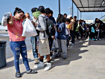 Migrants line up as they wait for a bus to Chicago to transport them out of Eagle Pass, Texas on September 26, 2023, at the Mission Border Hope complex, an NGO that assists migrants after they are processed by the US Customs and Border Patrol and with transportation around the …