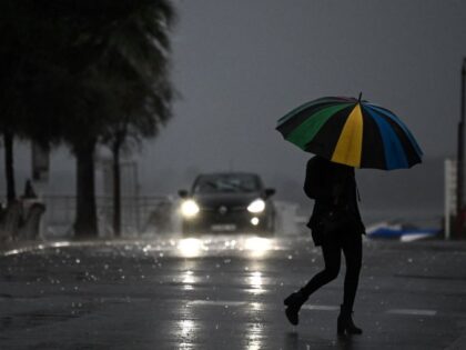 TOPSHOT - A woman holding an umbrella crosses a street under the rain ahead of storm Ciaran on November 1, 2023, in Arcachon, south-western France. France went on high alert as a storm dubbed Ciaran threatened to bring gale-force winds and extreme rainfall to the north and west, as well …