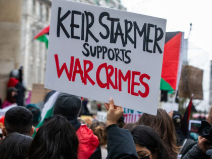 A pro-Palestinian protester holds up a sign outside the BBC accusing the Leader of the Opp