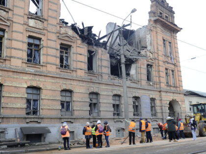 KHARKIV, UKRAINE - NOVEMBER 3: City utility workers stand outside the destroyed building o