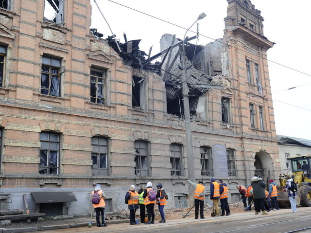 KHARKIV, UKRAINE - NOVEMBER 3: City utility workers stand outside the destroyed building o