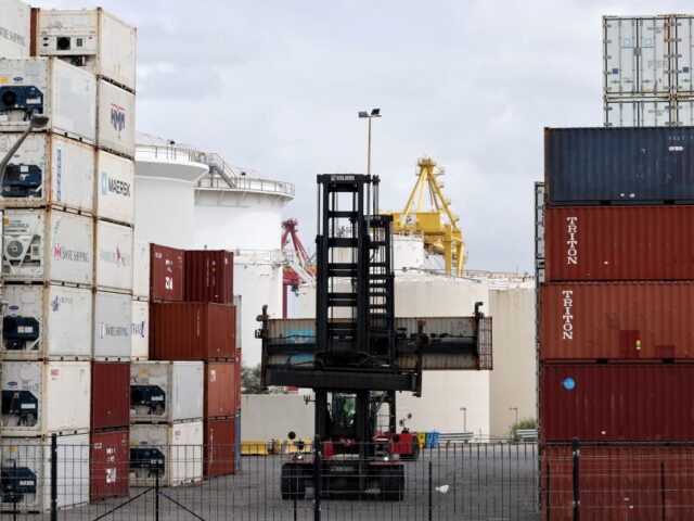 A worker moves containers at the compound of ports operator DP World at Port Botany in Syd