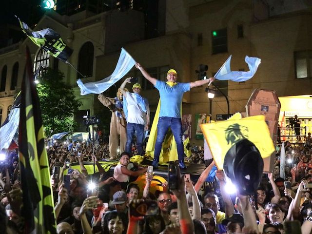Supporters of the Argentine presidential candidate for the La Libertad Avanza alliance, Javier Milei, celebrate his victory in the presidential election runoff outside the party headquarters in Buenos Aires on November 19, 2023. Libertarian outsider Javier Milei pulled off a massive upset Sunday with a resounding win in Argentina's presidential election, a stinging rebuke of the traditional parties that have overseen decades of economic decline. (Photo by Emiliano Lasalvia / AFP) (Photo by EMILIANO LASALVIA/AFP via Getty Images)