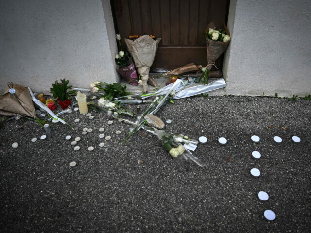 A photograph shows bunches of flowers and candles displayed in front of the reception hall