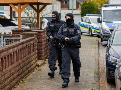 23 November 2023, Lower Saxony, Garbsen: Police officers walk through a housing estate during a raid. During a raid against a smuggling network, the police arrested a man wanted on a warrant. A house and several cars were searched. Photo: Ole Spata/dpa (Photo by Ole Spata/picture alliance via Getty Images)