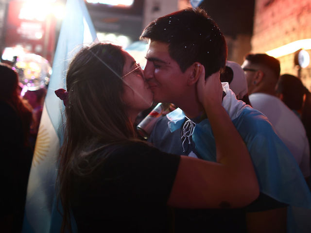 BUENOS AIRES, ARGENTINA - NOVEMBER 19: Supporters of newly elected Argentine President Javier Miley of La Libertad Avanza kiss after polls close in the presidential runoff on November 19, 2023 in Buenos Aires, Argentina.  According to the official results, Javier Miley from La Libertad Avanza received 55.69% of the votes, and Sergio Massa from Union Por la Patria received 44.30% after 99.25 votes were counted.  The presidential election runoff to succeed Alberto Fernandez comes at a time when Argentines have been hit hard by an annual inflation rate of 142.7%.  (Photo by Thomas Cuesta/Getty Images)