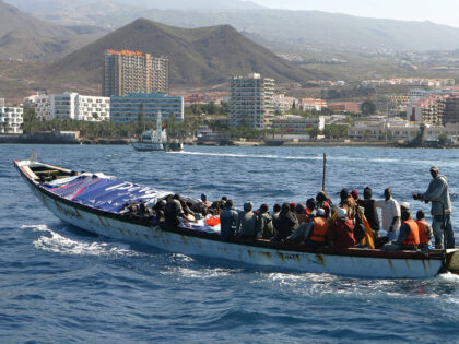 TENERIFE, CANARY ISLANDS - MAY 22: Would be immigrants arrive, under police escort, at Los Cristianos port on May 22, 2006 in Tenerife, Spain. Seventy-eight sub-Saharan male immigrants were spotted off the Tenerife coastline after making the crossing from the west African shores. (Photo by Denis Doyle/Getty Images)