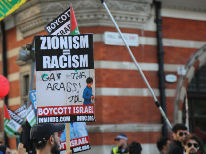 LONDON, UNITED KINGDOM - JUNE 10: A demonstrator holds a banner reading "Zionism = Racism" during the Al Quds Day demonstration in London, United Kingdom on June 10, 2018. The demonstrators gathered at the Saudi Arabia's Embassy and began the march from here, passed through Piccadilly road and Trafalgar street …