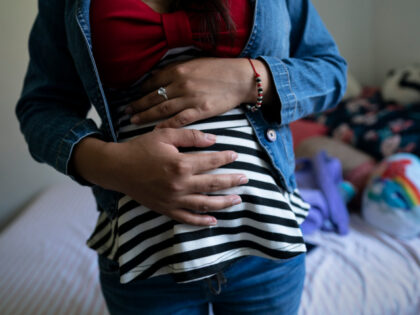 WORTHINGTON, MN - SEPTEMBER 5: A 15-year-old from Honduras stands in her bedroom after school in Worthington, Minn., September 5, 2019. When she set out on her journey to the U.S., she didnt know she was pregnant. Her baby is due next month. (Photo by Courtney Perry/For the Washington Post)