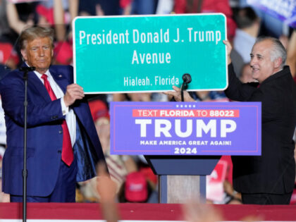 Former President Donald Trump holds a sign with Hialeah Mayor Esteban Bovo at a campaign r