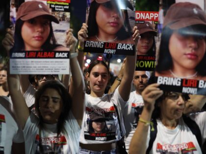 11 November 2023, Israel, Tel Aviv: People carry posters during a protest calling for the