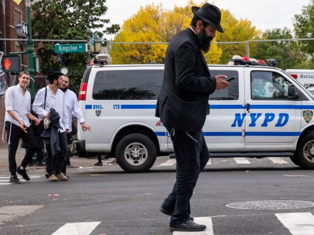NEW YORK, NEW YORK - OCTOBER 12: A person walks as police patrol a neighborhood in Brooklyn with a large Orthodox Jewish community on October 12, 2023, in New York City. Across New York City and much of the nation, security has been increased around synagogues and other Jewish cultural …
