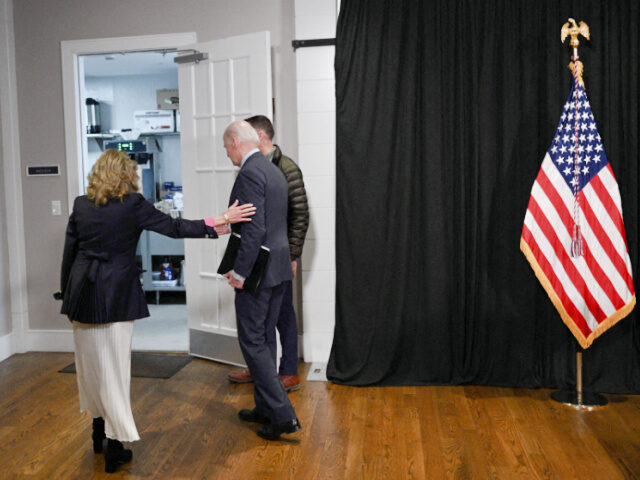 US President Joe Biden, with First Lady Jill Biden (L), leaves after speaking about the re