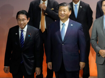 Japan's Prime Minister Fumio Kishida, left, stands next to Chinese President Xi Jinping du