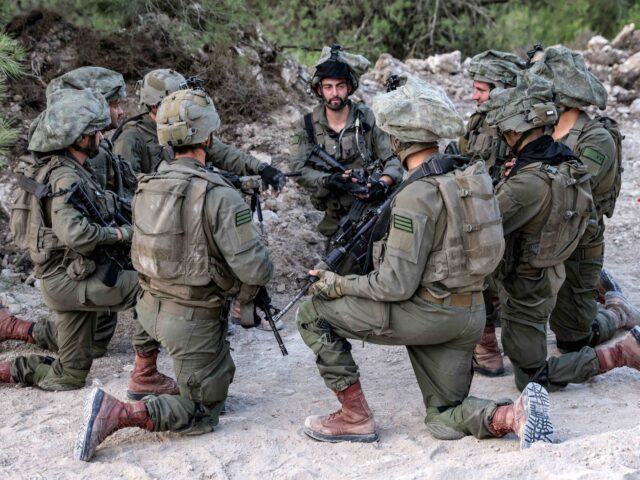 Kneeling Israeli soldiers (Jalaa Marey / AFP via Getty)