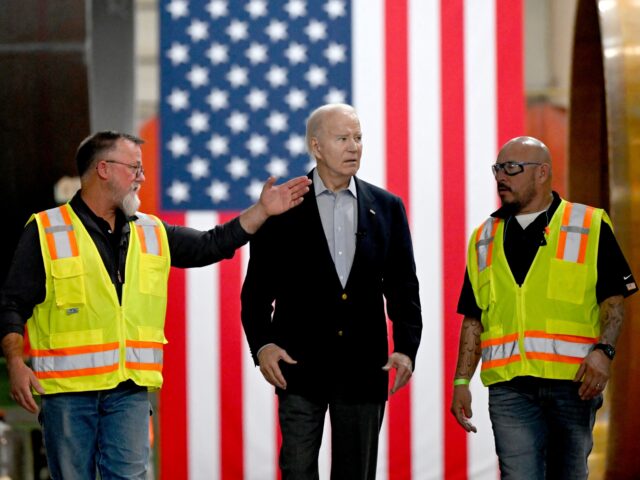 US President Joe Biden speaks with workers while touring CS Wind, the largest wind tower m