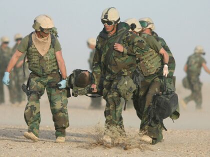 A U.S. Marine is carried on a stretcher to a waiting ambulance. This Marine sustained life