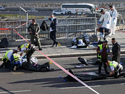 Israeli paramedics cover the bodies of suspected attackers as they secure the site of a sh