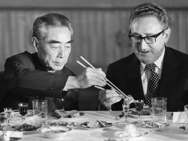 U.S. Secretary of State Henry Kissinger accepts food from Chinese Premier Zhou Enlai durin