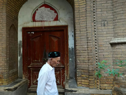 This photo taken on on July 13, 2023 shows a Uyghur man walking past a closed mosque in Ka