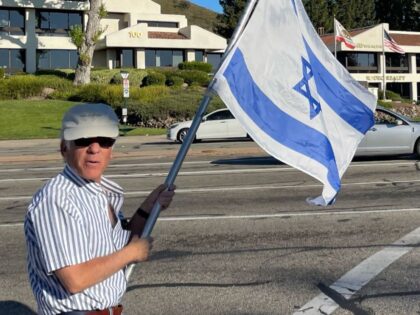 This photo, taken Sunday, shows Paul Kessler holding an Israeli flag at the intersection w