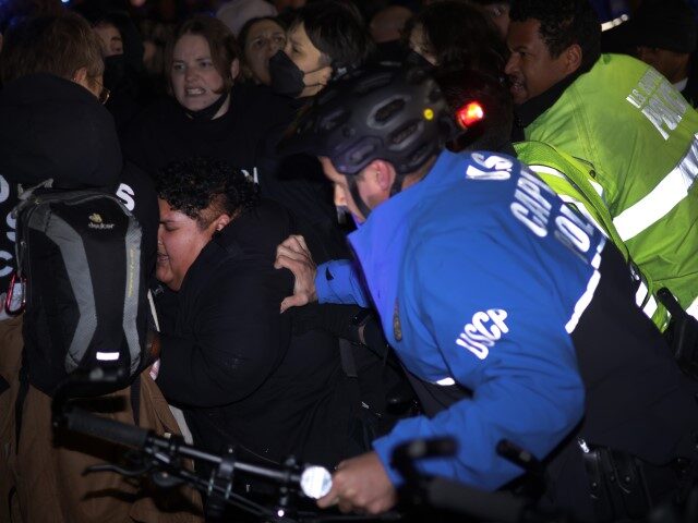 Members of U.S. Capitol Police try to push protesters away from the headquarters of the De