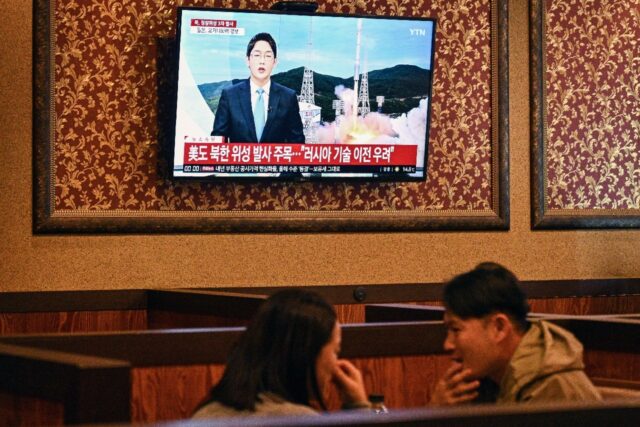 Customers sit near a television showing a news broadcast at a restaurant in Seoul on Novem