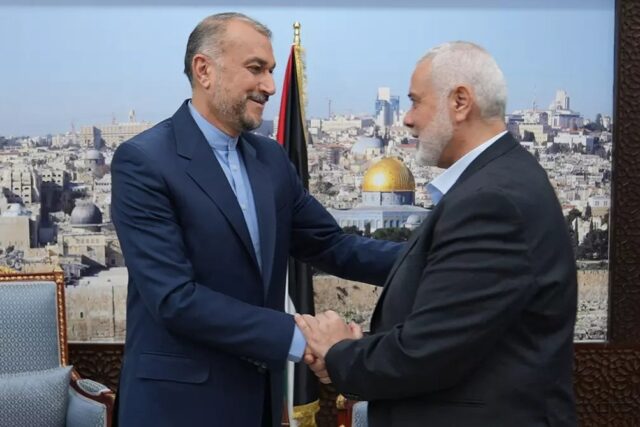 Iranian Foreign Minister Hossein Amir Abdollahian (L) greets Hamas political bureau chief