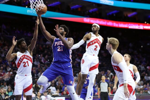 Joel Embiid of the Philadelphia 76ers drives past Thaddeus Young and Jalen McDaniels of the Toronto Raptors in the Sixers' 114-99 NBA victory over the Raptors