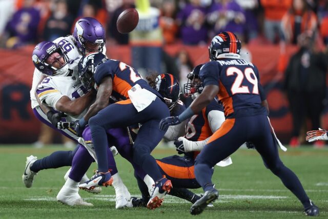 Minnesota quarterback Joshua Dobbs, left, fumbles after being hit by Denver defensive back