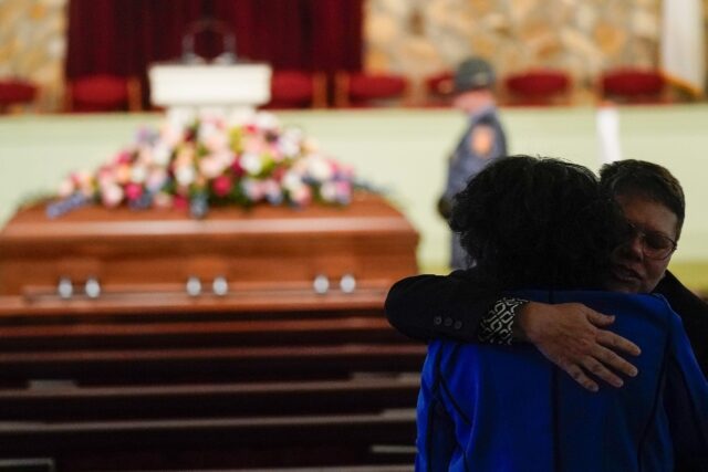 Mourners embrace as they arrive at the funeral service for former first lady Rosalynn Cart