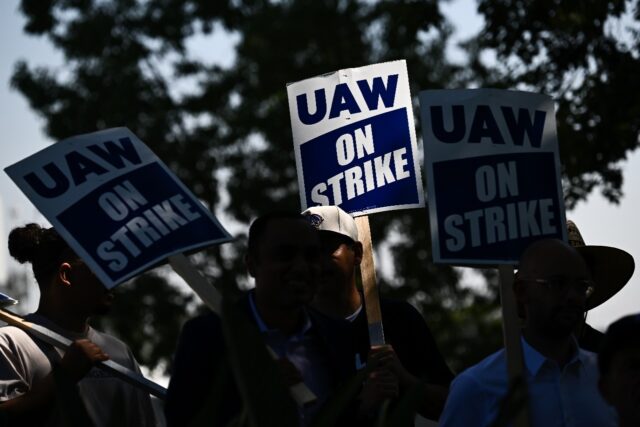 Members of the United Auto Workers (UAW) Local 230 and their supporters walk the picket li