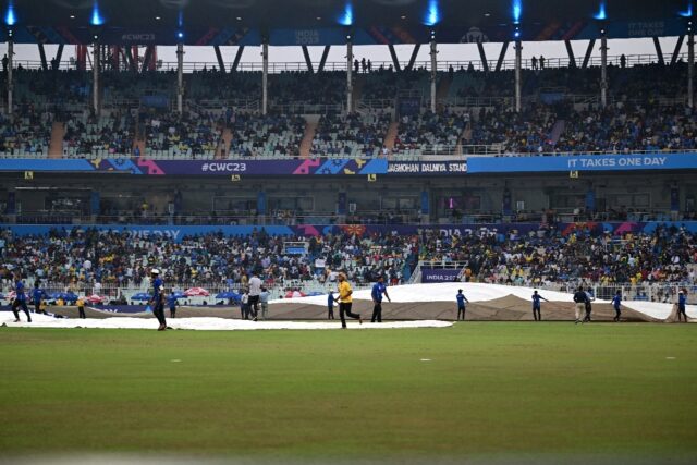 Rain pain: Ground staff cover the pitch after rain stops play in Kolkata on Thursday