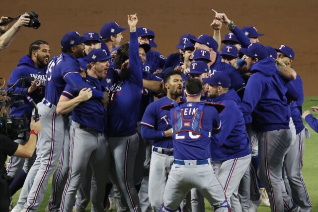The Texas Rangers celebrate after beating the Arizona Diamondbacks 5-0 to clinch the team'