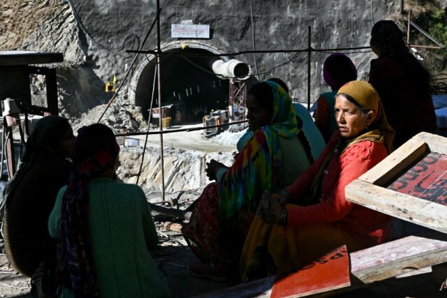 Women sit overlooking the entrance of the Silkyara tunnel, days after it collapsed