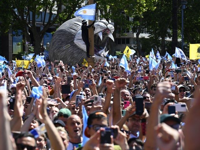 Supporters of Argentina's new president Javier Milei celebrate as he speaks at the cr